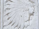 relief représentant un homme coiffé d'une coiffe à plumes, sur un mur de pierre