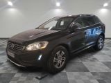 Le SUV Volvo noir est garé sur un sol en carrelage à damier.