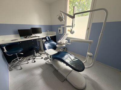 a dentist ' s chair in the corner of the room