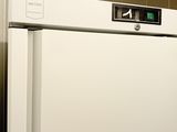 a white refrigerator with a clock on it in a kitchen