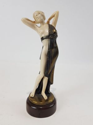 une image représentant une statue d'une femme en robe posée sur un socle en bois