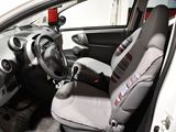 the interior of a small car with a steering wheel and seat covers
