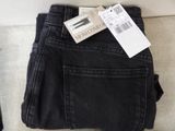 two pairs of black jeans with a price tag on them