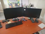 two computer monitors and a keyboard on a desk