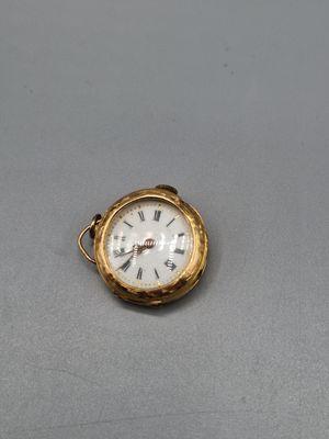 une petite montre de poche en or avec des chiffres romains
