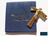 une croix dorée sur un tissu bleu, avec un crucifix doré