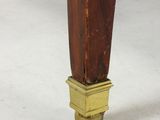 the legs of a wooden table with a brass plate on it