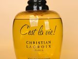 un flacon de parfum jaune avec un bouchon rouge sur fond beige