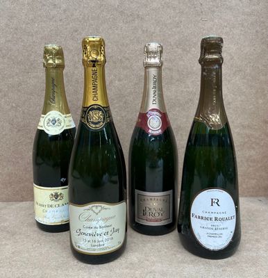 quatre bouteilles de champagne sont alignées sur une table