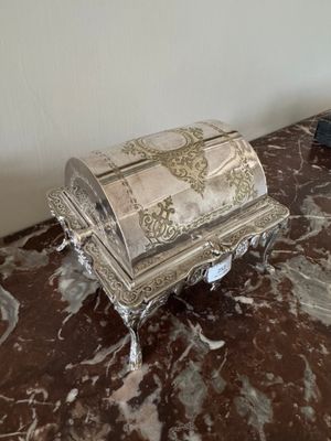 une boîte en argent posée sur une table en marbre