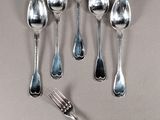 six spoons and a fork on a table