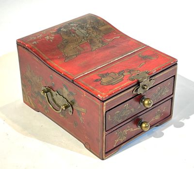 une petite boîte rouge ornée de motifs dorés