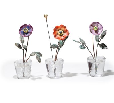 three glass vases with flowers in them sitting next to each other