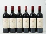six bouteilles de vin rouge alignées sur une surface blanche