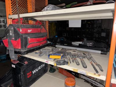 de nombreux outils posés sur une étagère dans un garage