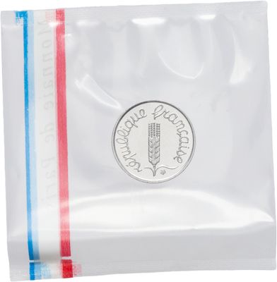 un gros plan d'une pièce de monnaie dans un sachet en plastique sur fond blanc