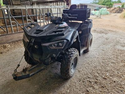 a black atv with a trailer attached to it in a barn