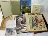 Plusieurs livres sont posés sur une table recouverte d'une nappe blanche.