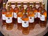 many bottles of wine sitting on a wooden table