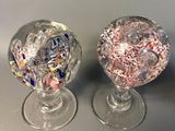 two glass vases sitting on a table with confetti sprinkles in them