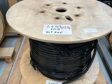 une bobine de fil noir posée sur une palette dans un entrepôt