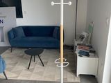 a living room with a blue couch and a white coat rack