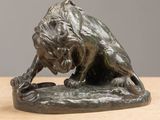 bronze statue of a lion on a rock on a table