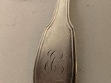 a silver spoon and a spoon with a monogram on it