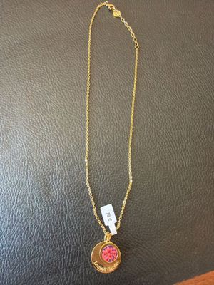 un collier en or orné d'une pierre rose
