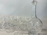 many wine glasses and a decanter sitting on a table