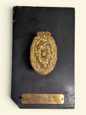 une plaque accrochée au mur sur laquelle est apposée une autre plaque