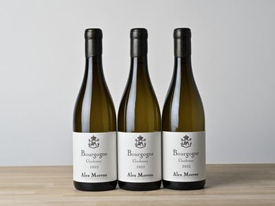 trois bouteilles de vin posées sur une table en bois