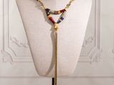 a mannequin with a gold chain and multi colored beads