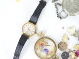 a watch that is sitting next to a bunch of jewelry