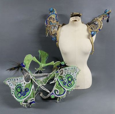 une image représentant un mannequin blanc orné de décorations vertes et bleues