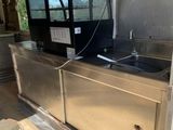 a stainless steel kitchen with a sink inside of it