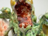 a green dragon figurine sitting on top of a table