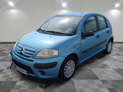la petite voiture bleue est garée sur un carrelage à carreaux