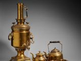 two brass teapots and a tray with a kettle on it