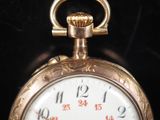 a close up of a gold pocket watch on a black background
