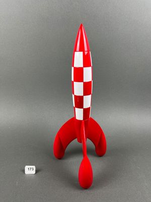a red and white toy rocket sitting on top of a table