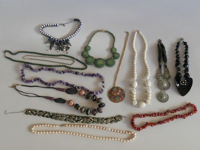 tout un tas de colliers et de bracelets différents posés sur la table