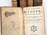 Plusieurs vieux livres sont posés sur une table, accompagnés d'une étiquette de prix.