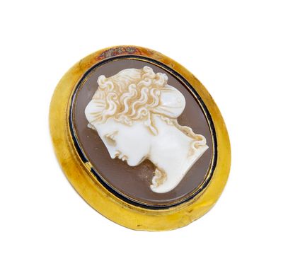 a close up of a gold plated broochle with a woman ' s face