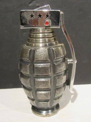 a small metal grenade shaped object on a white table