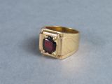 an image of a gold ring with a garnett stone