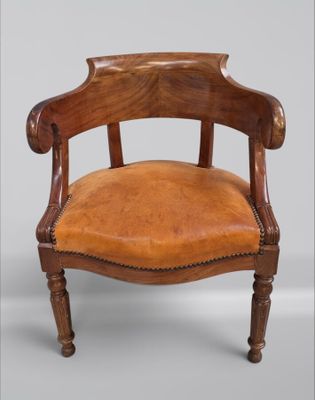 une vieille chaise en bois avec une assise en cuir marron sur fond gris