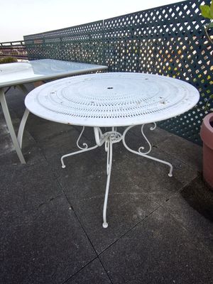 une table blanche et deux chaises sur une terrasse