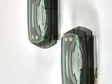pair of green glass wall sconces mounted on a white wall