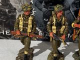 three figurines of soldiers with guns on a table